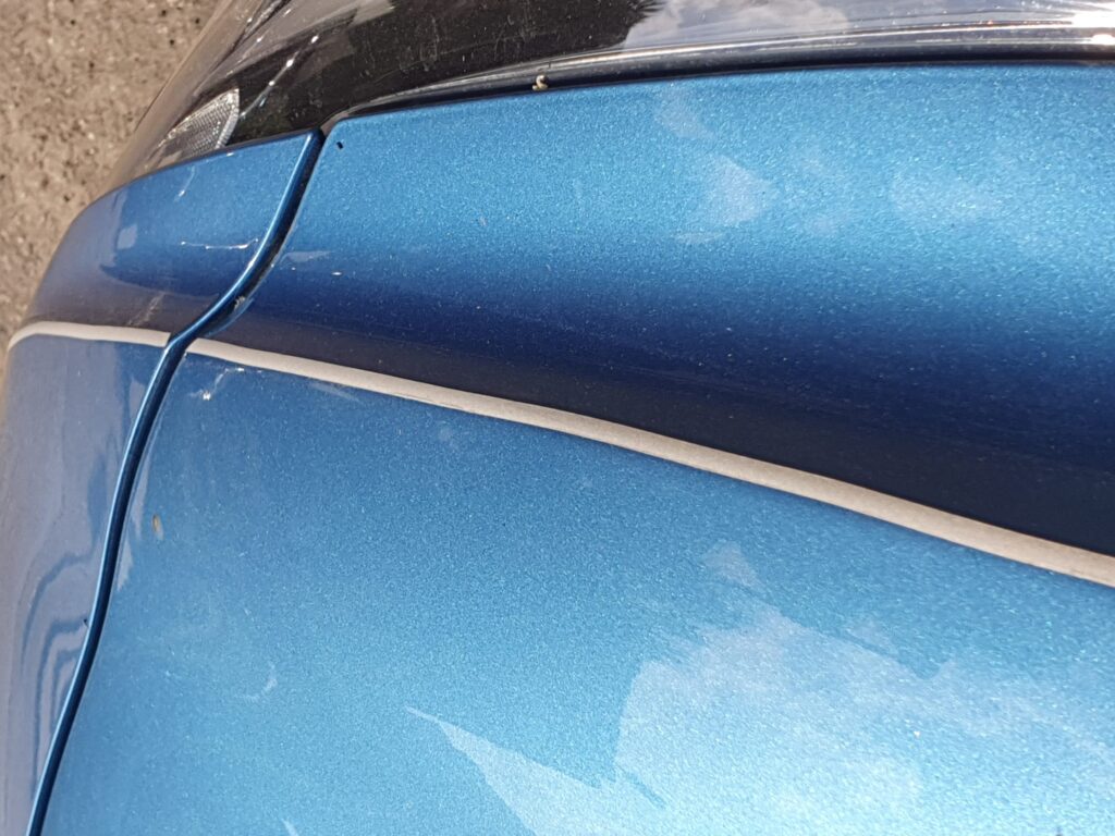silbernes Klebeband auf blauem Auto